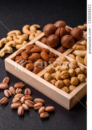 Wooden box with macadamia nuts, almonds, pistachios, and hazelnuts. Nuts as a food background Wooden box with macadamia nuts, almonds, pistachios, and hazelnuts. Nuts as a food background 138088821