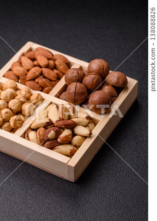 Wooden box with macadamia nuts, almonds, pistachios, and hazelnuts. Nuts as a food background Wooden box with macadamia nuts, almonds, pistachios, and hazelnuts. Nuts as a food background 138088826