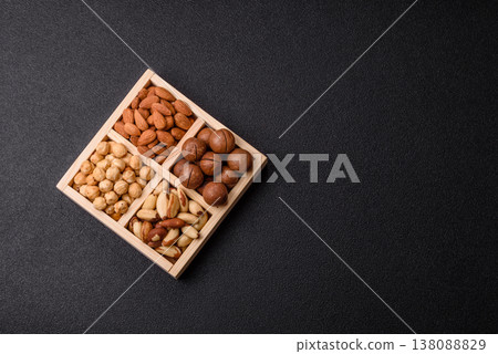 Wooden box with macadamia nuts, almonds, pistachios, and hazelnuts. Nuts as a food background Wooden box with macadamia nuts, almonds, pistachios, and hazelnuts. Nuts as a food background 138088829
