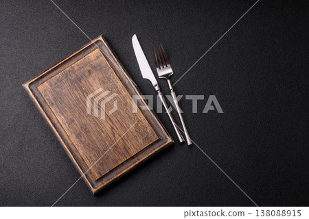 An empty wooden cutting board with cutlery on a kitchen counter. A wooden cutting board An empty wooden cutting board with cutlery on a kitchen counter. A wooden cutting board 138088915