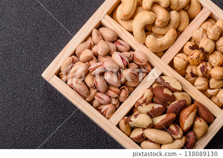 A box of cashews, hazelnuts, pistachios, and Brazil nuts as healthy food ingredients. A box of nuts 138089130