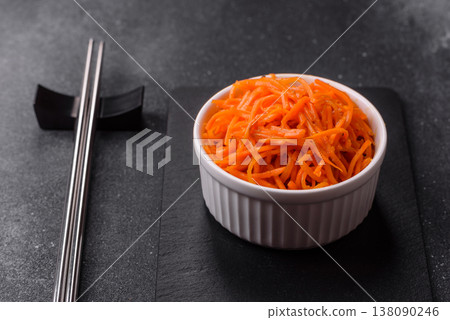 Spicy Korean carrot salad, grated with salt and spices, an Asian dish. Korean carrots Spicy Korean carrot salad, grated with salt and spices, an Asian dish. Korean carrots 138090246