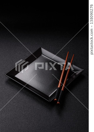 An empty ceramic square black plate with chopsticks for Asian food. An empty square plate 138090276