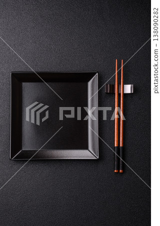 An empty ceramic square black plate with chopsticks for Asian food. An empty square plate 138090282