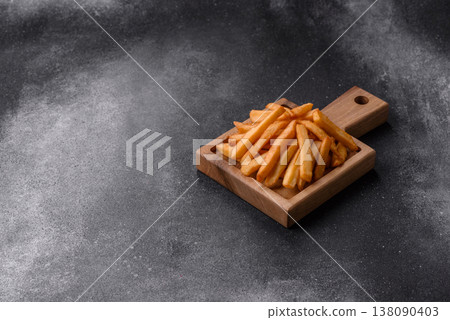 French fries, a salty, crispy, homemade snack with spices. French fries on a black background French fries, a salty, crispy, homemade snack with spices. French fries on a black background 138090403