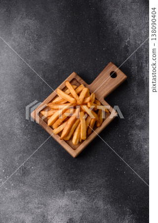 French fries, a salty, crispy, homemade snack with spices. French fries on a black background 138090404