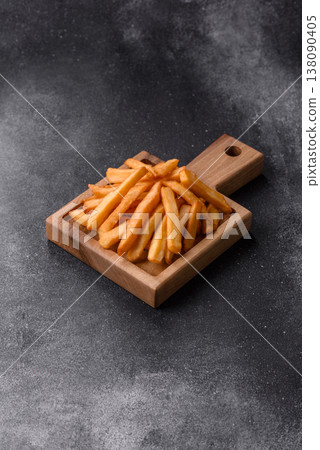 French fries, a salty, crispy, homemade snack with spices. French fries on a black background French fries, a salty, crispy, homemade snack with spices. French fries on a black background 138090405