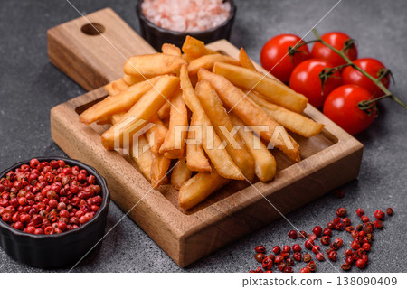 French fries, a salty, crispy, homemade snack with spices. French fries on a black background French fries, a salty, crispy, homemade snack with spices. French fries on a black background 138090409