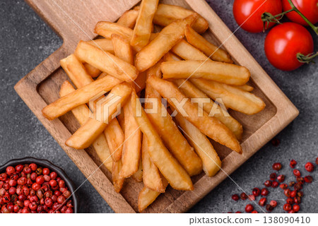 French fries, a salty, crispy, homemade snack with spices. French fries on a black background French fries, a salty, crispy, homemade snack with spices. French fries on a black background 138090410