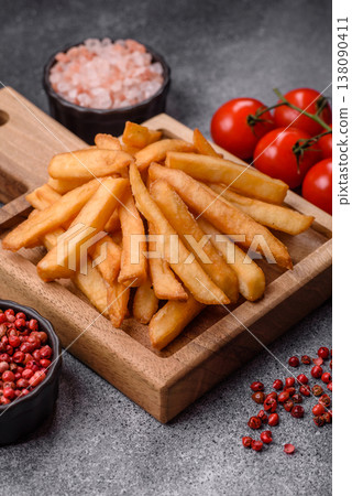 French fries, a salty, crispy, homemade snack with spices. French fries on a black background 138090411