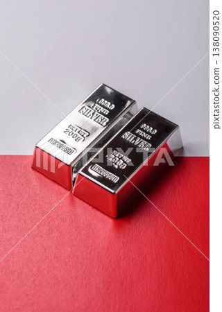 A silver bar, white metal against a backdrop of Polish flag, as a concept. A silver bar 138090520