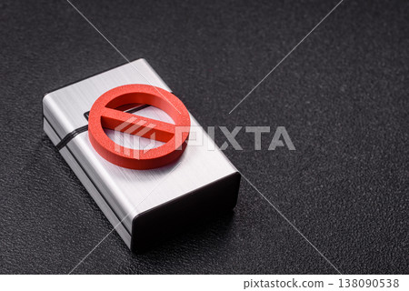 A metal cigarette box with a no smoking sign depicts a harmful habit. A cigarette box A metal cigarette box with a no smoking sign depicts a harmful habit. A cigarette box 138090538