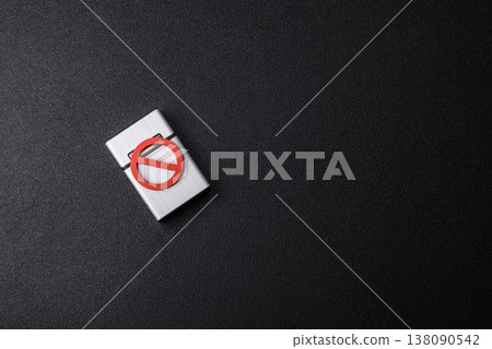 A metal cigarette box with a no smoking sign depicts a harmful habit. A cigarette box A metal cigarette box with a no smoking sign depicts a harmful habit. A cigarette box 138090542