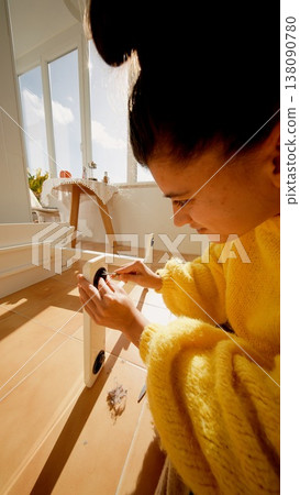 Woman In Cozy Kitchen Concentrating On Aligning Screw While Recording Detailed Tutorial On Smartphone Woman In Cozy Kitchen Concentrating On Aligning Screw While Recording Detailed Tutorial On Smartphone 138090780