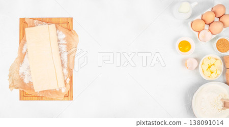 Puff pastry dough and baking ingredients on white background, top view preparation composition with copy space Puff pastry dough and baking ingredients on white background, top view preparation composition with copy space 138091014