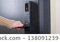 A woman opens a modern smart door lock with a digital keypad and biometric fingerprint access. 138091239