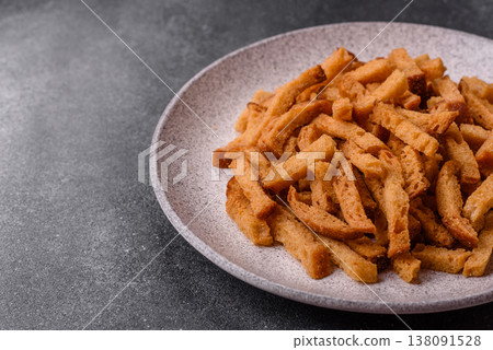 Croutons or crackers made from rye bread with garlic, salt, and spices. Croutons with salt Croutons or crackers made from rye bread with garlic, salt, and spices. Croutons with salt 138091528