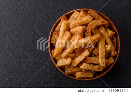 Croutons or crackers made from rye bread with garlic, salt, and spices. Croutons with salt Croutons or crackers made from rye bread with garlic, salt, and spices. Croutons with salt 138091554