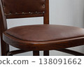 Elegant wooden chair with rich brown leather seat in a cozy indoor setting brings warmth and style to any room decor 138091662