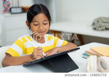 Asian girl with headphones enjoying online class on digital tablet Asian girl with headphones enjoying online class on digital tablet 138091718