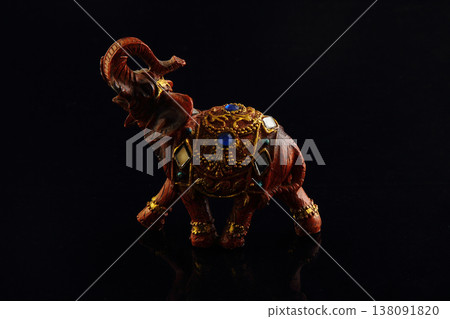a small elephant statues with black background. 138091820