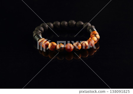 Shamballa bracelet made of wood on a black mirrored background 138091825