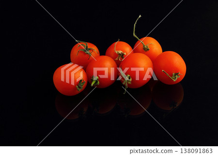 Fresh cherry tomatoes on a black background. Bunch of fresh cherry tomato on a black background Fresh cherry tomatoes on a black background. Bunch of fresh cherry tomato on a black background 138091863
