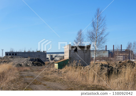 Abandoned industrial landscape with small brick building and factory structures in background Abandoned industrial landscape with small brick building and factory structures in background 138092042