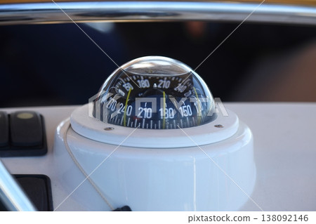 A big compass on a boat showing direction. Harbor background. 138092146