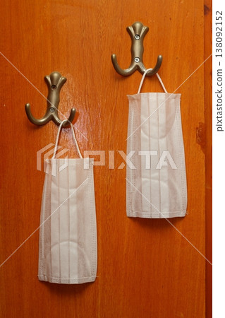 N95 mask hangs near the front door during quarantine. 138092152