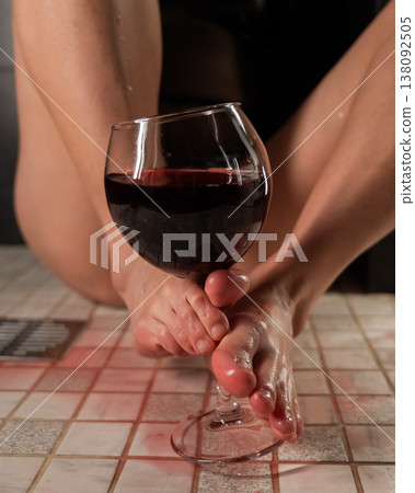 Foot fetish. A woman pours wine on her feet. Foot fetish. A woman pours wine on her feet. 138092505