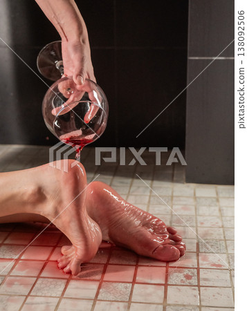 Foot fetish. A woman pours wine from a glass onto her feet in the shower. Foot fetish. A woman pours wine from a glass onto her feet in the shower. 138092506