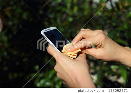 Close Up Of Hands Cleaning And Disinfecting The Phone Close Up Of Hands Cleaning And Disinfecting The Phone 138092571