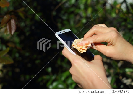 Close Up Of Hands Cleaning And Disinfecting The Phone Close Up Of Hands Cleaning And Disinfecting The Phone 138092572