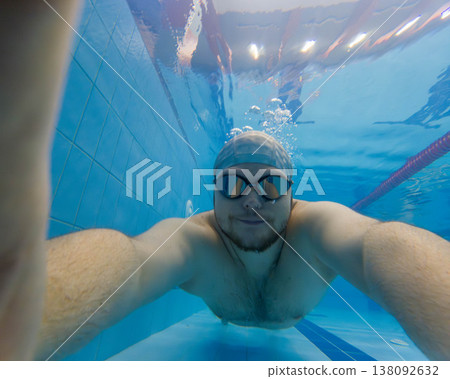 Underwater selfie of swimmer in blue pool with goggles Underwater selfie of swimmer in blue pool with goggles 138092632