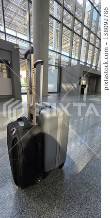 Black and silver luggage bags in modern airport terminal with glass walls Black and silver luggage bags in modern airport terminal with glass walls 138092786
