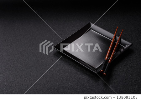 An empty ceramic square black plate with chopsticks for Asian food. An empty square plate 138093105
