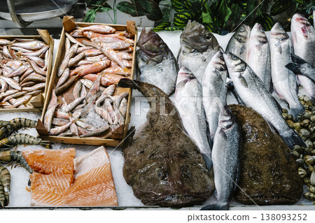 Fresh seafood assortment on ice at a traditional fish market. A variety of raw dorado, sea bream, and large fish fillets displayed with lobster for gourmet cooking 138093252