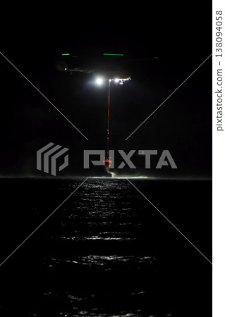 night vision firefighting helicopter takes water from the sea. 138094058