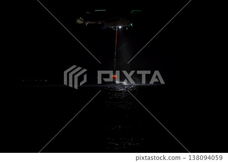 night vision firefighting helicopter takes water from the sea. night vision firefighting helicopter takes water from the sea. 138094059