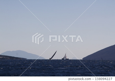 Sailing ship yachts with white sails in race the regatta in the open sea Sailing ship yachts with white sails in race the regatta in the open sea 138094227
