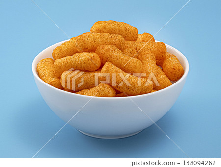 Crispy corn sticks in white bowl isolated on blue background, full depth of field 138094262
