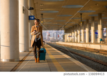 Woman Using Smartphone While Walking at Train Station Woman Using Smartphone While Walking at Train Station 138094413