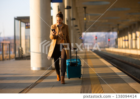 Modern Woman Checking Phone on Train Platform Modern Woman Checking Phone on Train Platform 138094414