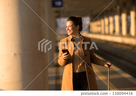Thoughtful Woman with Suitcase at Modern Train Station 138094416