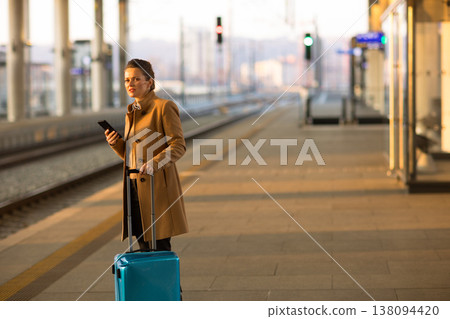 Professional Woman Waiting for Train with Suitcase 138094420