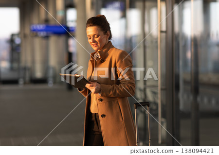 Woman Reviewing Digital Travel Ticket at Station Woman Reviewing Digital Travel Ticket at Station 138094421