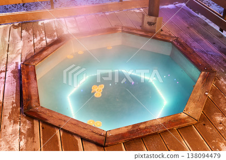 Contemporary octagonal tub featuring calming steam and glowing lighting 138094479