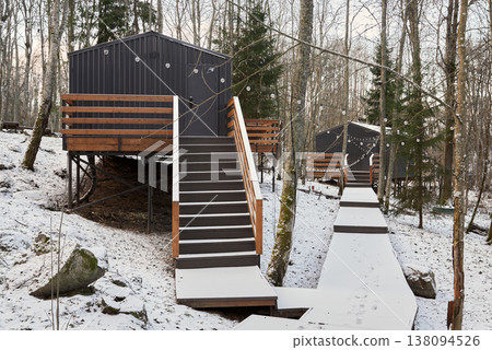 Serene retreat with snowcovered path linking cabin residences 138094526