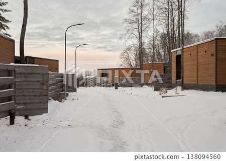 Quiet rural street illuminated by soft sunrise and distant lamps 138094560